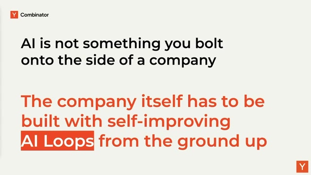 全场核心论点幻灯片：「AI is not something you bolt onto the side of a company（AI 不是你贴在公司侧面的东西）/ The company itself has to be built with self-improving AI Loops from the ground up（公司本身必须从地基起、用自我改进的 AI 循环来搭）」——AI Loops 被高亮标红