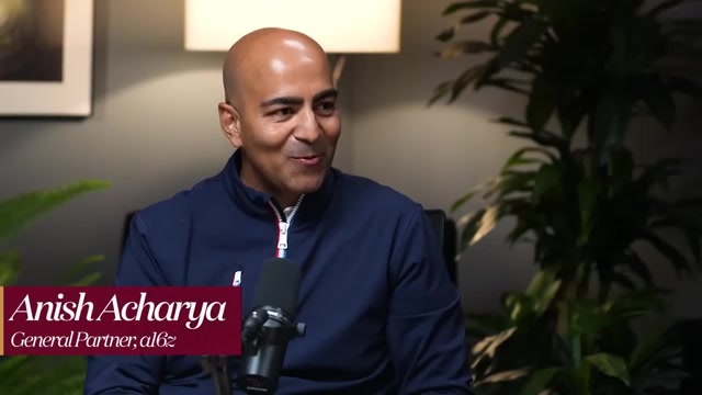 主持人 Anish Acharya，a16z 普通合伙人（General Partner）——视频下方字幕条标明其身份